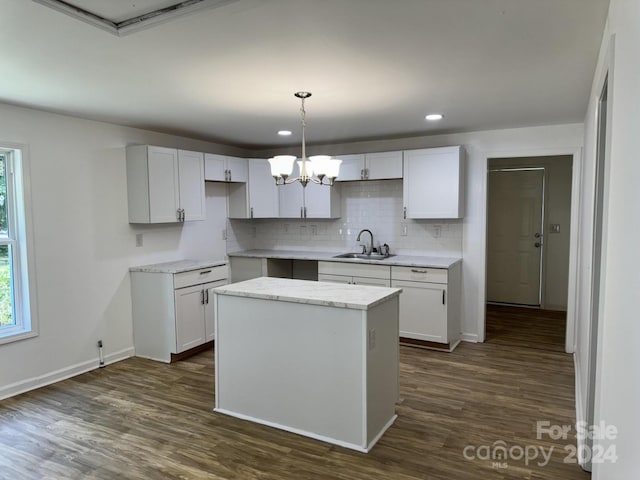 kitchen with sink, pendant lighting, and white cabinets