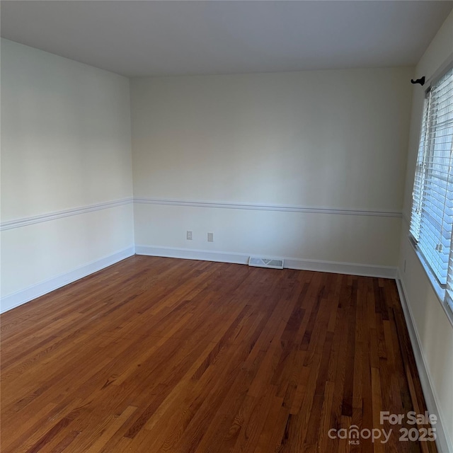 unfurnished room with dark wood-type flooring