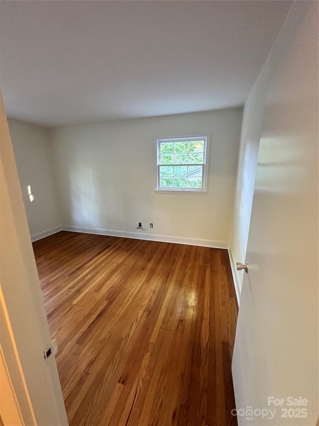 spare room featuring wood-type flooring