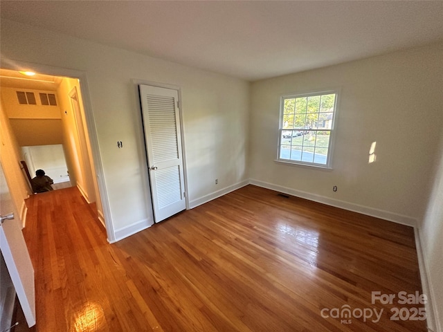 unfurnished bedroom featuring hardwood / wood-style flooring and a closet