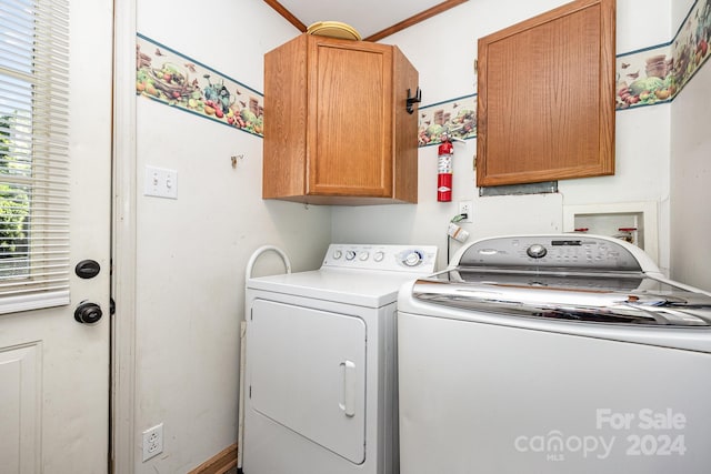 laundry room featuring cabinets, crown molding, and washing machine and dryer