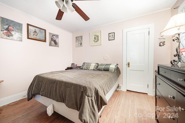 bedroom featuring ceiling fan, ornamental molding, and light hardwood / wood-style floors