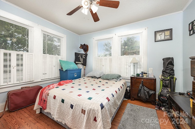 bedroom with multiple windows, dark hardwood / wood-style flooring, and ceiling fan