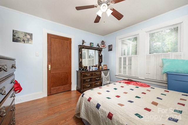 bedroom featuring ceiling fan, crown molding, and hardwood / wood-style floors