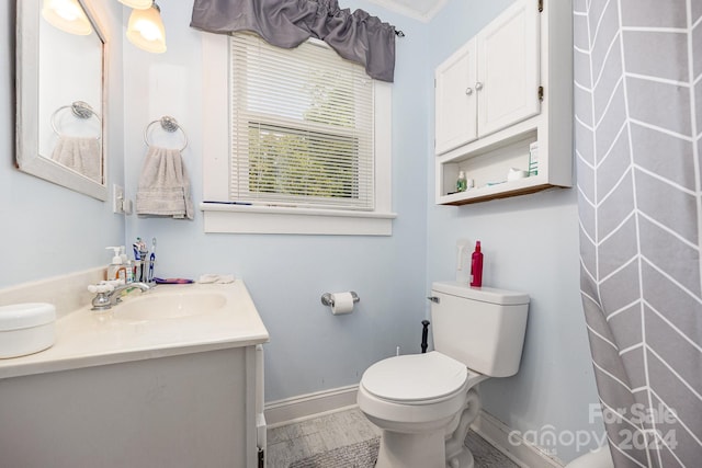 bathroom with ornamental molding, vanity, toilet, and hardwood / wood-style flooring