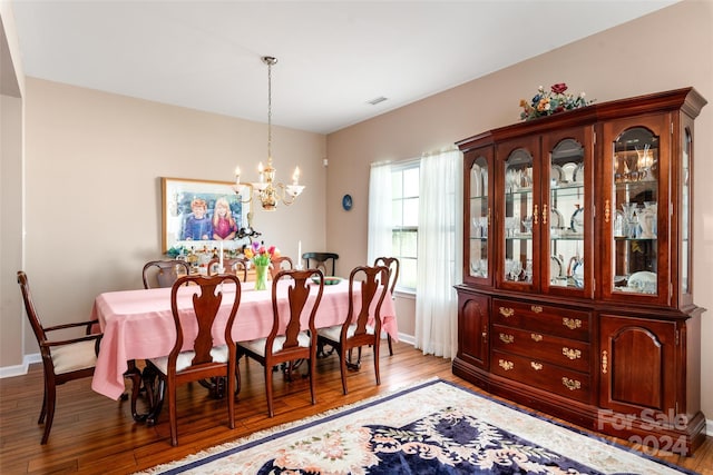 dining space featuring hardwood / wood-style floors and a notable chandelier