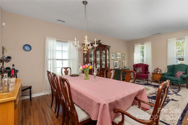 dining area featuring an inviting chandelier and dark hardwood / wood-style floors