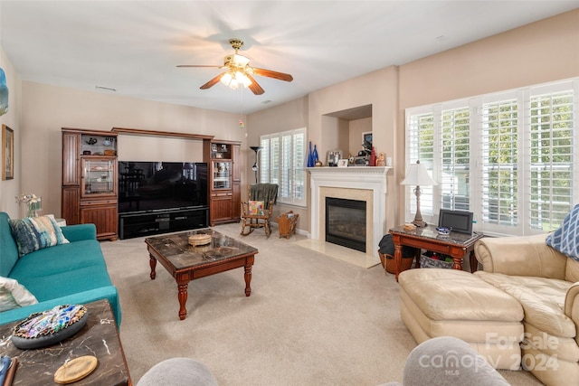 carpeted living room featuring ceiling fan and a fireplace