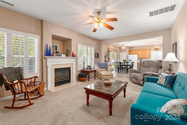 living room with light carpet, a wealth of natural light, and ceiling fan