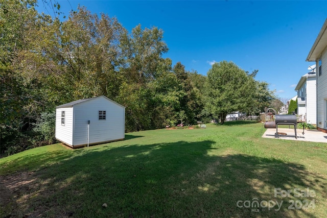 view of yard featuring a patio and a shed