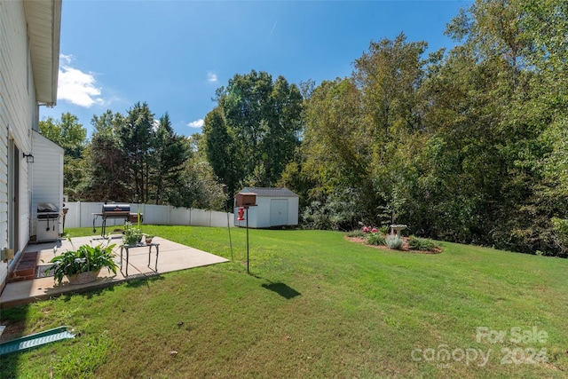 view of yard featuring a shed and a patio area