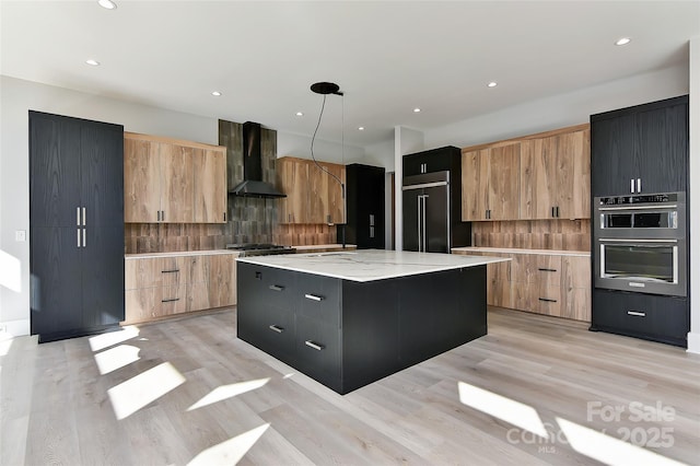 kitchen with a center island, built in refrigerator, wall chimney range hood, decorative light fixtures, and backsplash