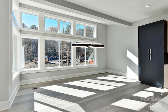 interior space with light wood-type flooring and a towering ceiling