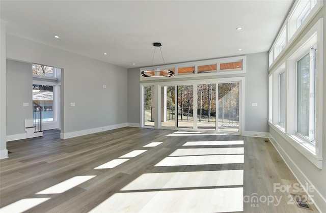 unfurnished living room featuring hardwood / wood-style flooring and a wealth of natural light