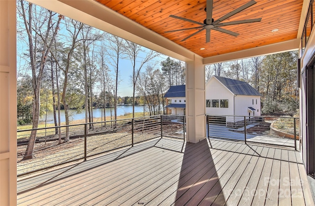 wooden terrace with a water view and ceiling fan