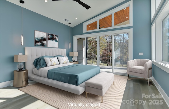 bedroom featuring ceiling fan, access to exterior, hardwood / wood-style floors, and high vaulted ceiling