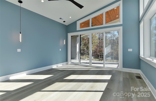 empty room featuring high vaulted ceiling, wood-type flooring, and ceiling fan