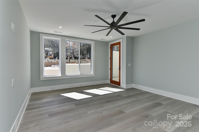 empty room with ceiling fan and light hardwood / wood-style floors