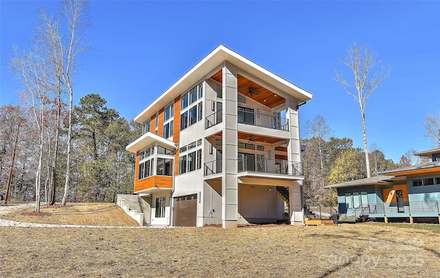 rear view of property with ceiling fan and a garage