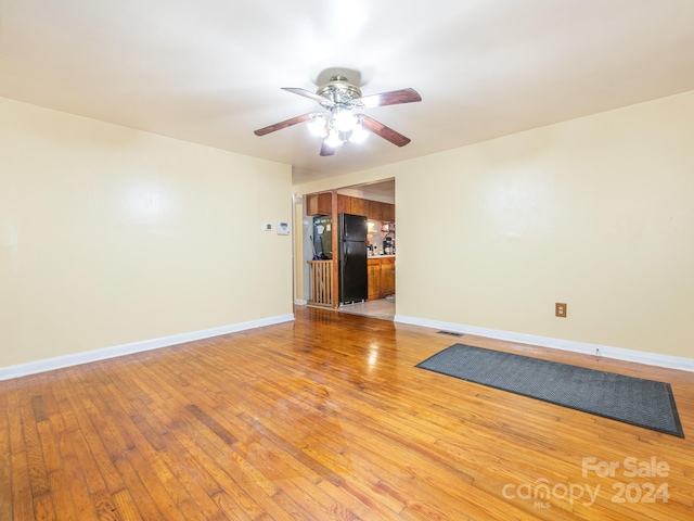 spare room with light wood-type flooring and ceiling fan