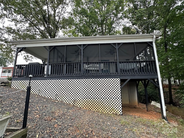 rear view of house with a sunroom and a wooden deck