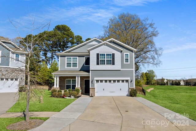 view of front of property featuring a front yard and a garage