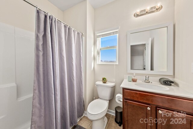 bathroom featuring a shower with shower curtain, tile patterned flooring, vanity, and toilet