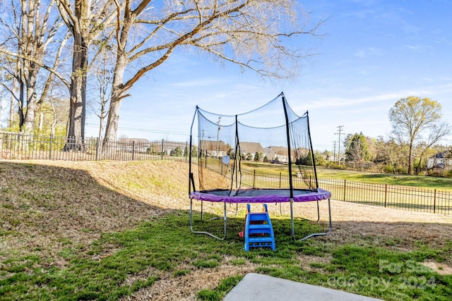 view of play area with a trampoline and a yard