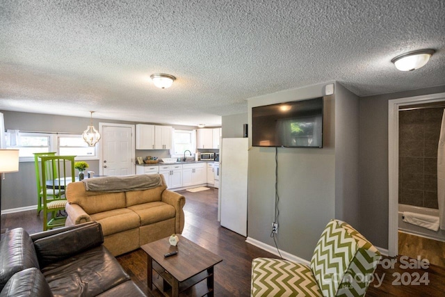 living room with a textured ceiling, sink, and dark wood-type flooring