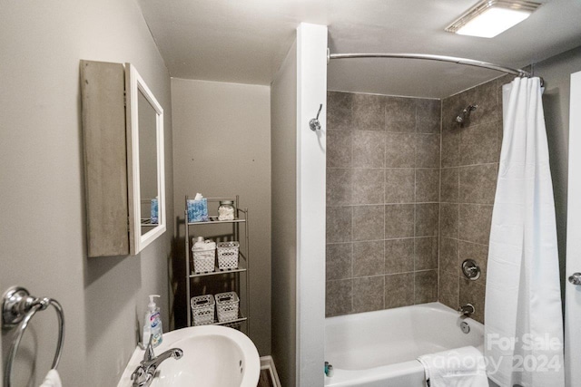 bathroom featuring shower / bath combo with shower curtain and sink