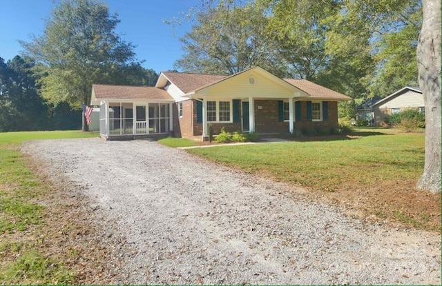 ranch-style home featuring a front yard and a sunroom