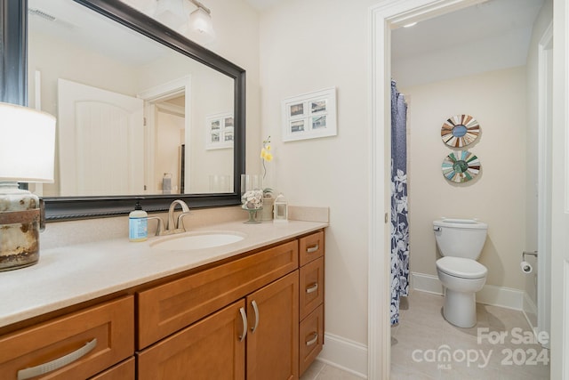 bathroom with vanity, tile patterned flooring, and toilet