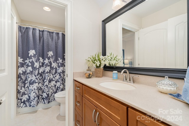 bathroom with a shower with shower curtain, vanity, toilet, and tile patterned floors