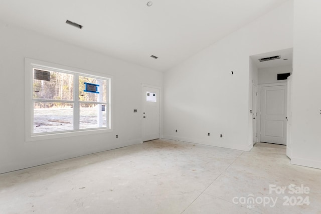 unfurnished room featuring lofted ceiling