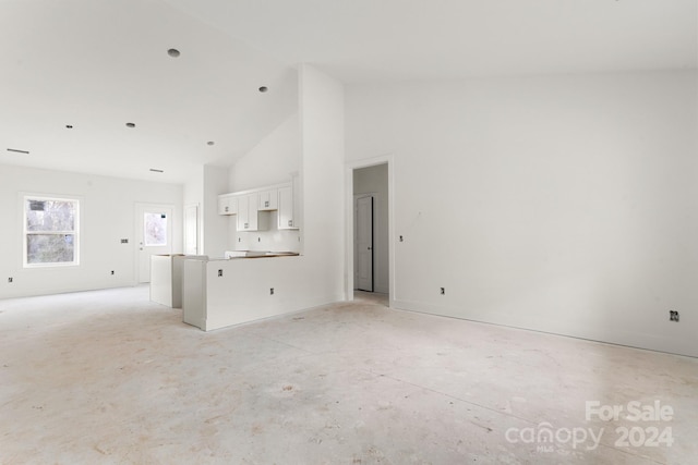 unfurnished living room featuring high vaulted ceiling