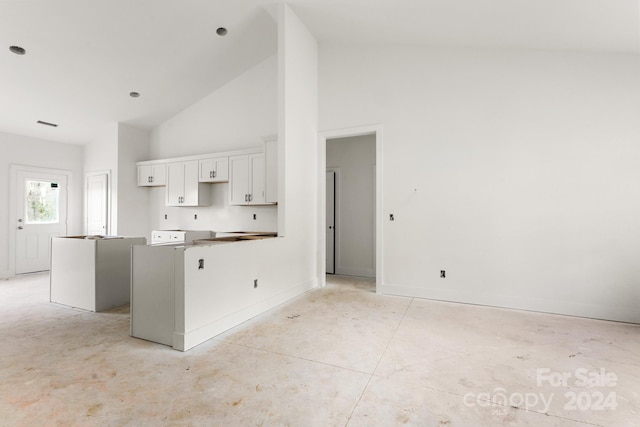 kitchen with a kitchen island, white cabinetry, and high vaulted ceiling