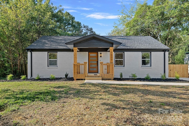 ranch-style house with a porch and a front yard