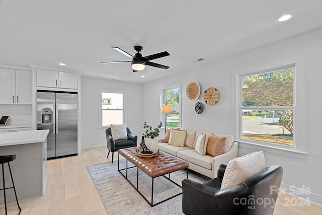 living room featuring light wood-type flooring and ceiling fan