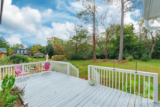 wooden deck featuring a lawn