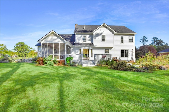 rear view of property with a sunroom and a yard