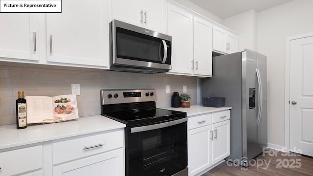 kitchen with dark wood finished floors, tasteful backsplash, light countertops, appliances with stainless steel finishes, and white cabinets