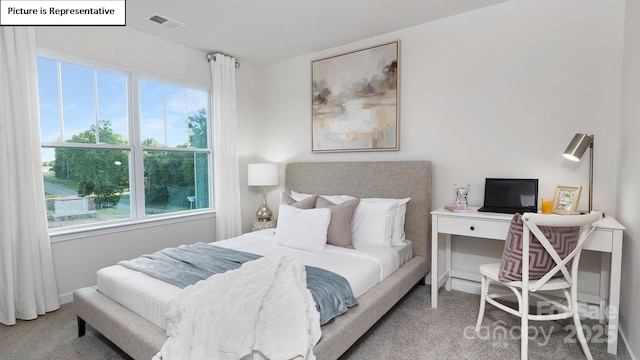 carpeted bedroom featuring visible vents