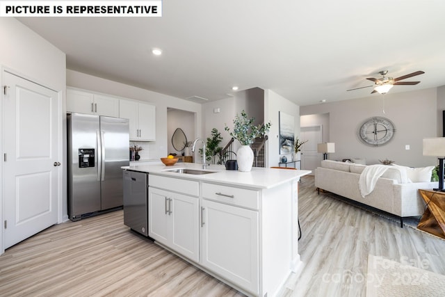 kitchen featuring white cabinets, sink, an island with sink, and appliances with stainless steel finishes