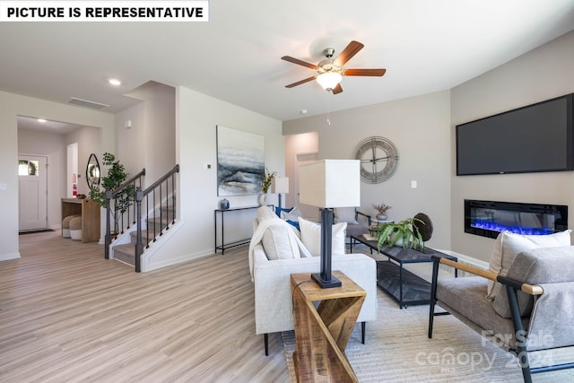 living room featuring ceiling fan and light hardwood / wood-style floors