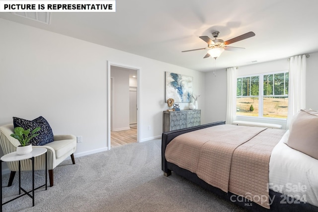 carpeted bedroom featuring ensuite bath and ceiling fan