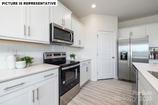 kitchen with white cabinetry, appliances with stainless steel finishes, light countertops, and backsplash