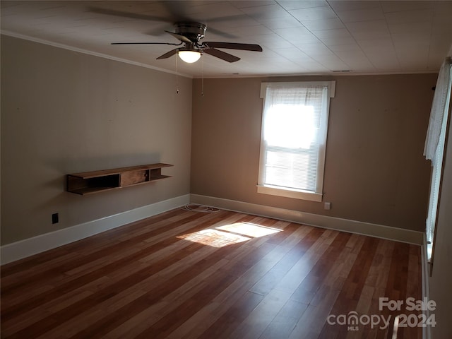 empty room with ceiling fan, dark hardwood / wood-style floors, and ornamental molding