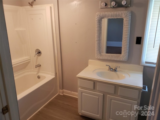 bathroom featuring wood-type flooring, shower / bath combination, and vanity