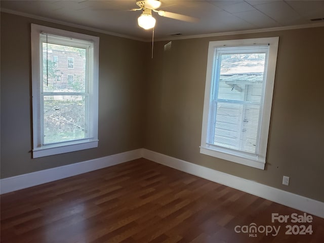 spare room featuring ceiling fan, dark wood-type flooring, and crown molding