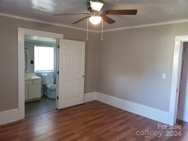 unfurnished bedroom featuring dark hardwood / wood-style flooring, sink, ensuite bathroom, crown molding, and ceiling fan